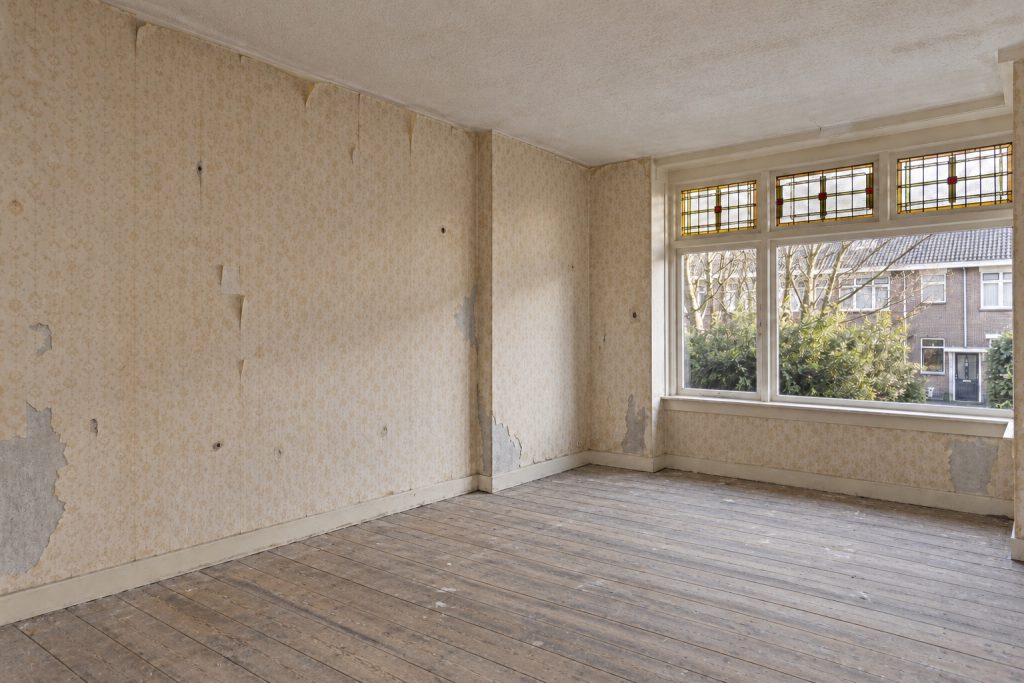 Woonkamer voor het werk, met oud behang en scheuren